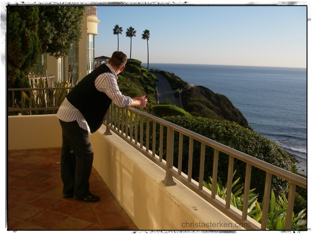 man on balcony overlooking the ocean