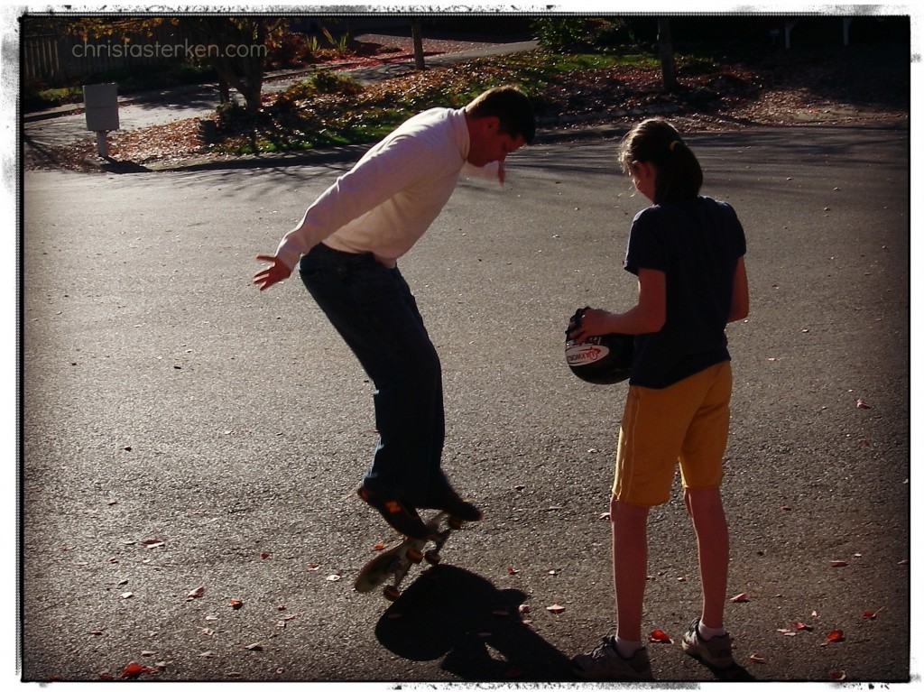 man showing his daughter skateboard tricks