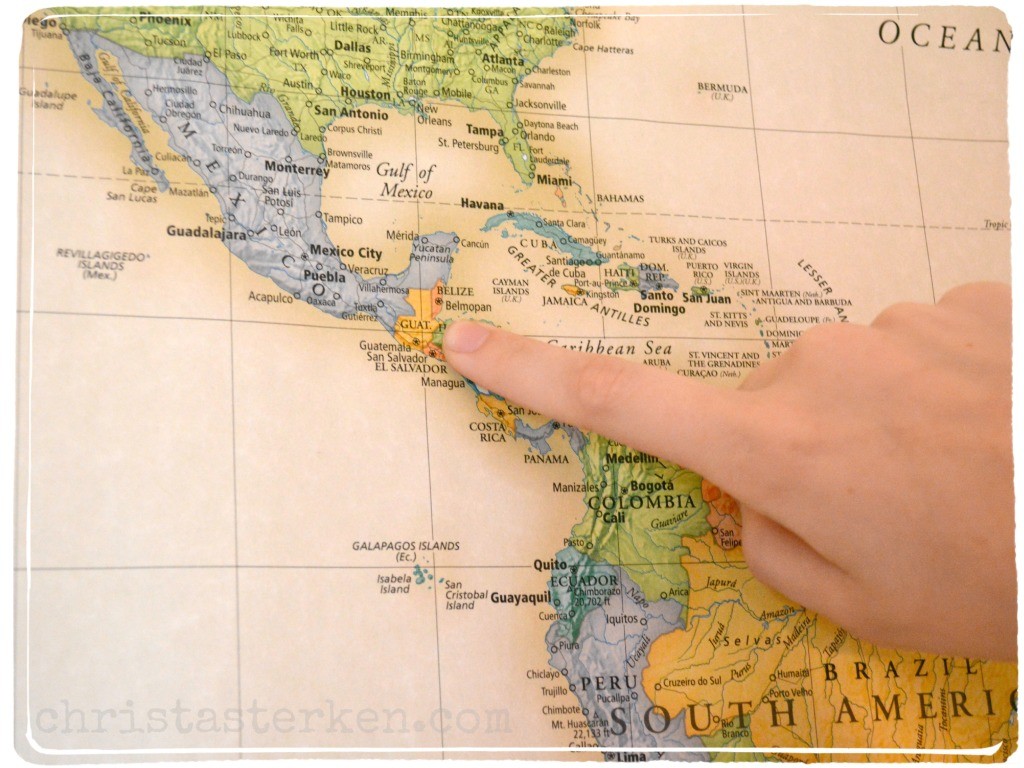 finger pointing to Guatemala on a map