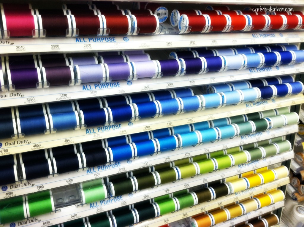rows of colorful thread on display at fabric store