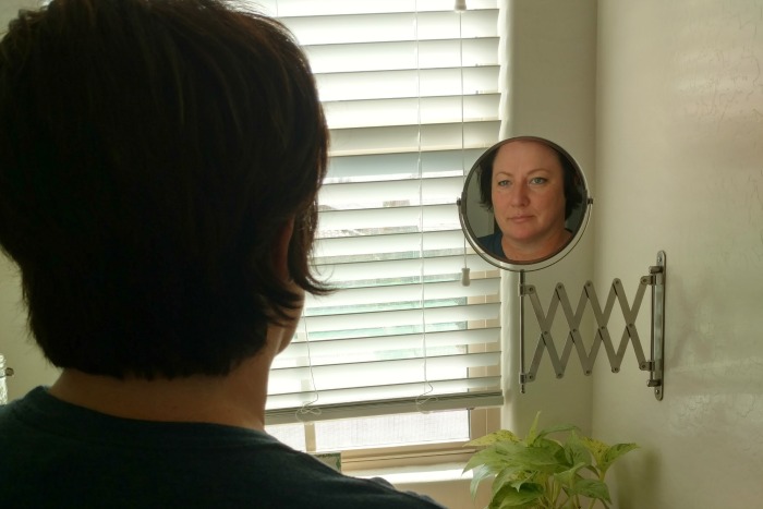 woman looking into a mirror reflectively