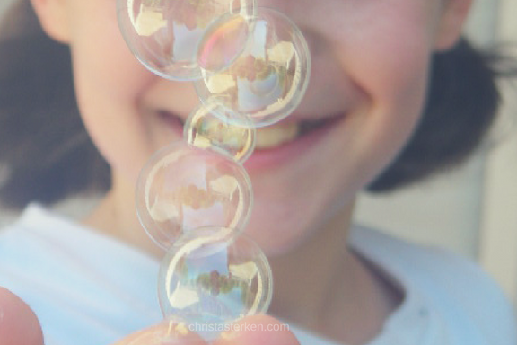 little girl blowing bubbles