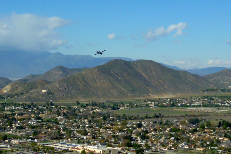 airplane flying over southern california valley