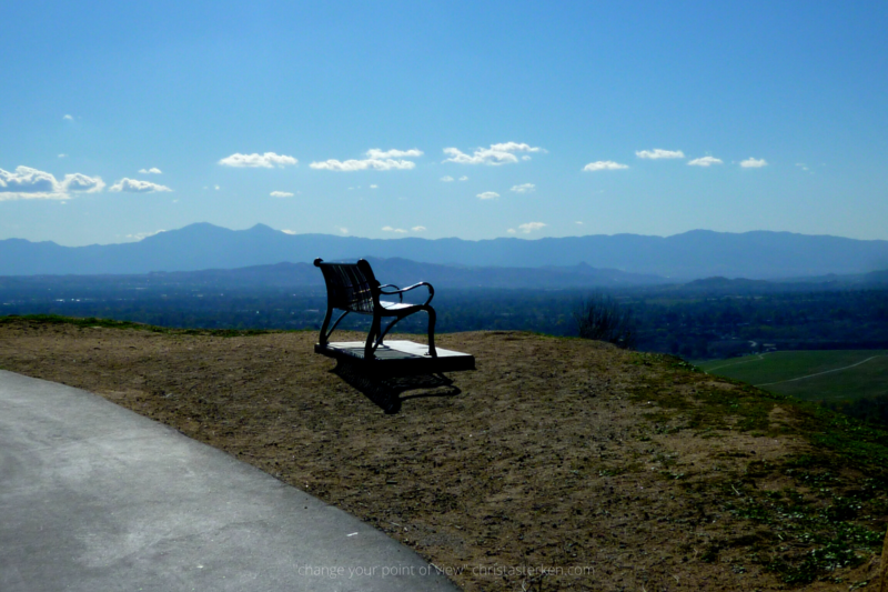 an empty bench overlooking a beautiful valley