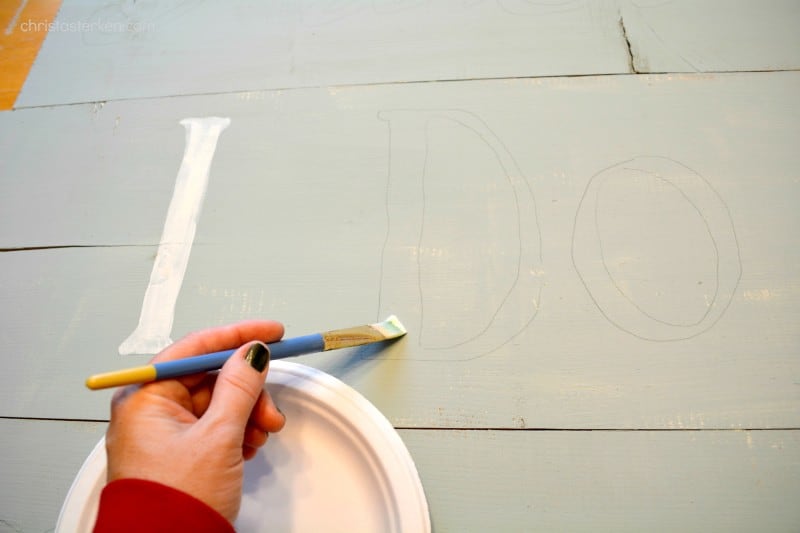 painting letters on homemade wooden sign