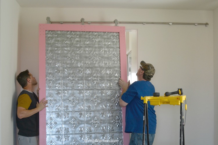 men hanging a barn door