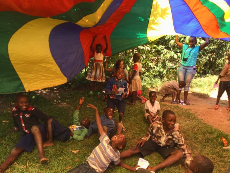 laughing children playing with parachute