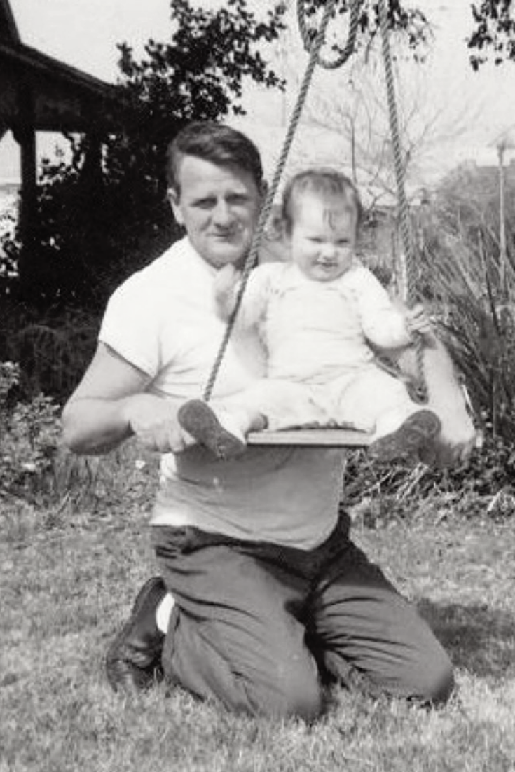 old picture of a grandpa pushing baby on swing