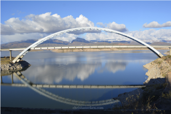 reflection of bridge over blue lake