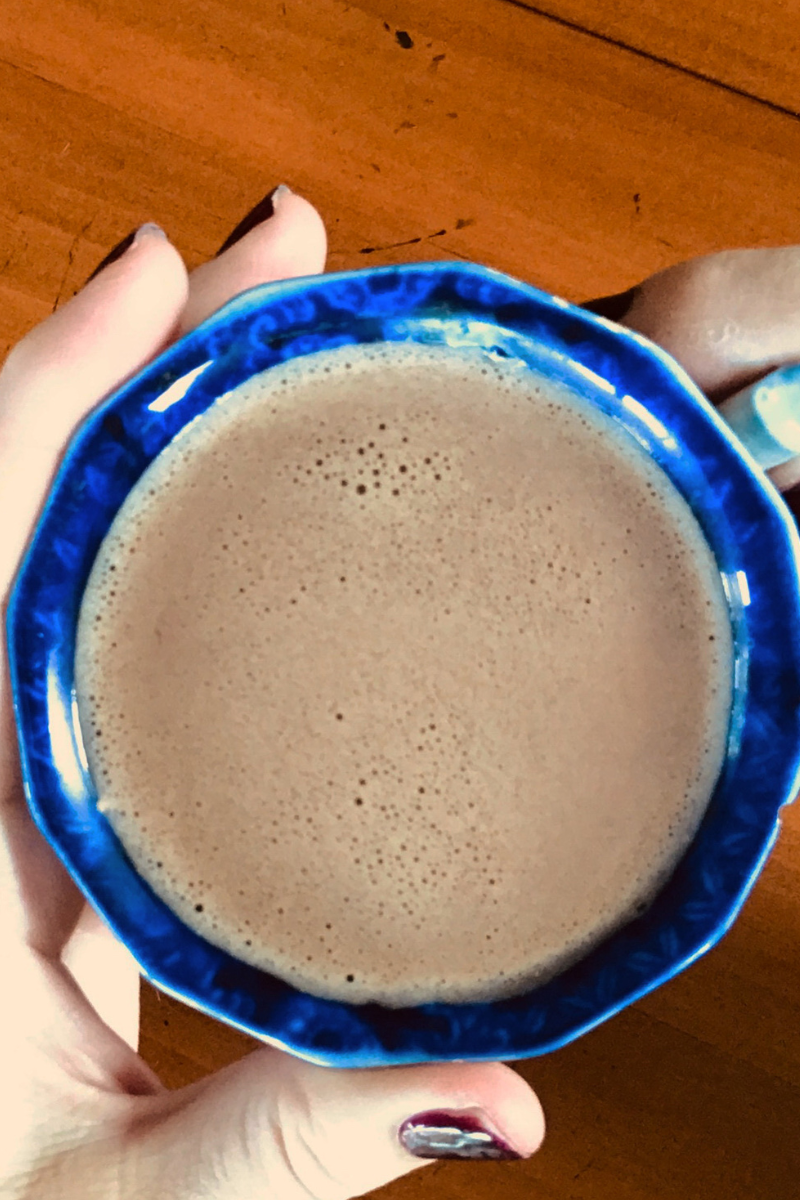 woman's hands holding glass of coffee