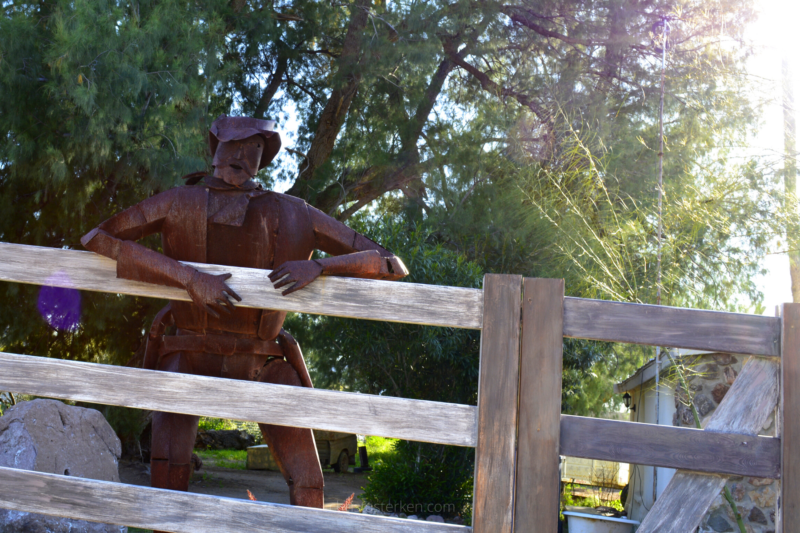 metal cowboy statue on fence