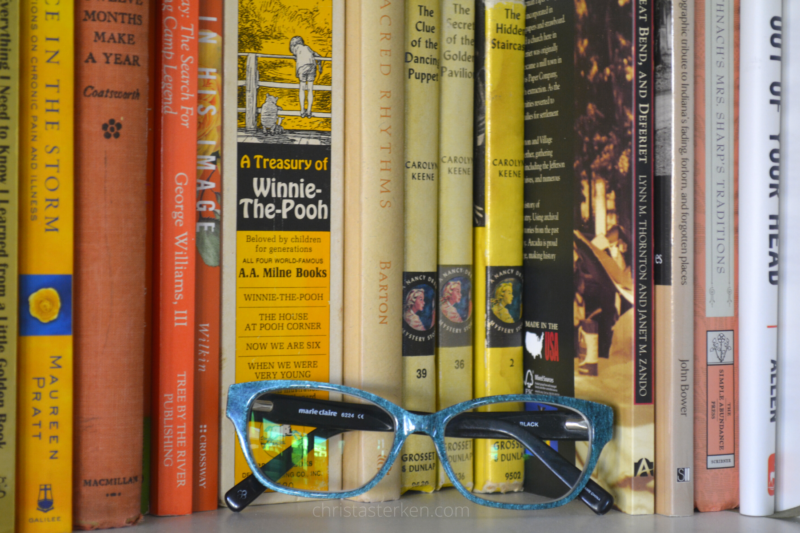 glasses in front of pile of books