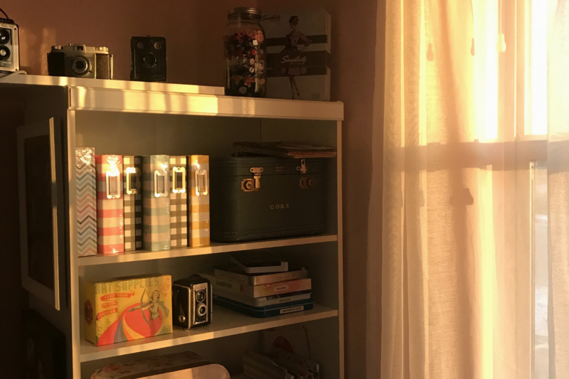 sun shining through curtains onto bookshelf