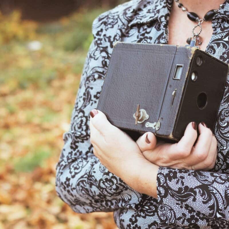 Woman holding vintage camera – faith family homemaking inspiration